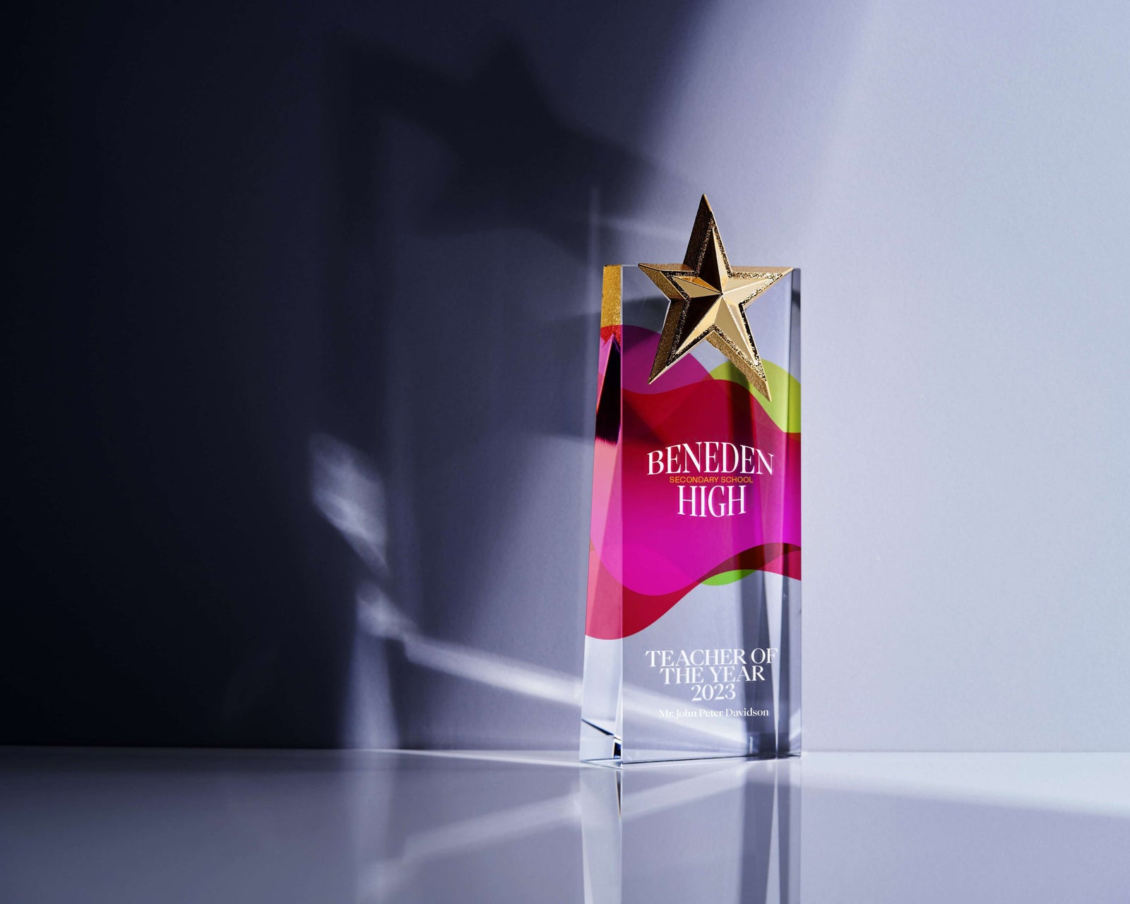 Beneden High Teacher of the Year 2022 award trophy with a golden star on a reflective surface.